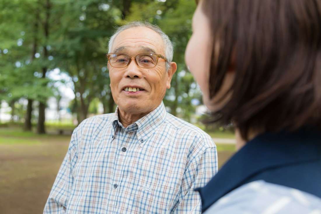 スタッフと話して笑顔になる男性