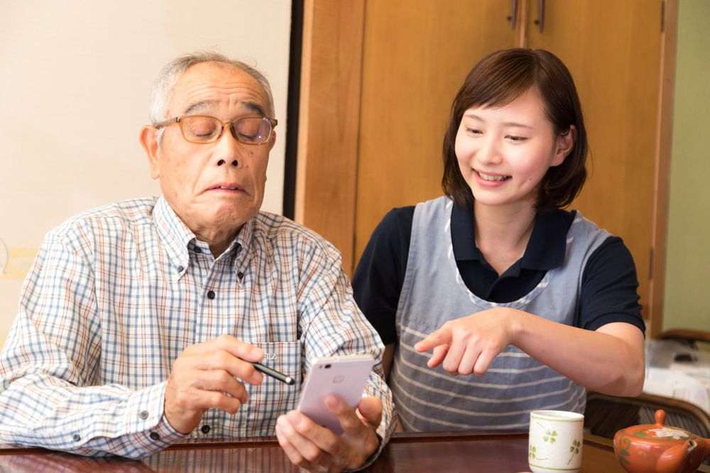 スマートフォンの使い方を教わる男性