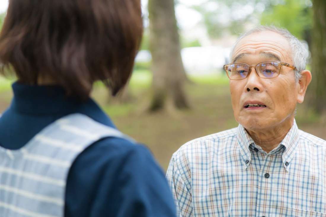 スタッフと向き合って話す男性