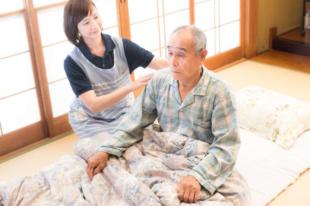 和室で男性に寄り添うスタッフ