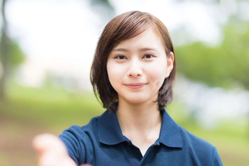 笑顔で手を差し伸べる支援員