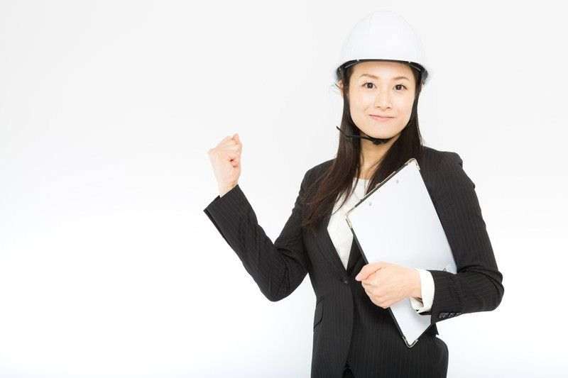 白いヘルメットをかぶりガッツポーズをする女性