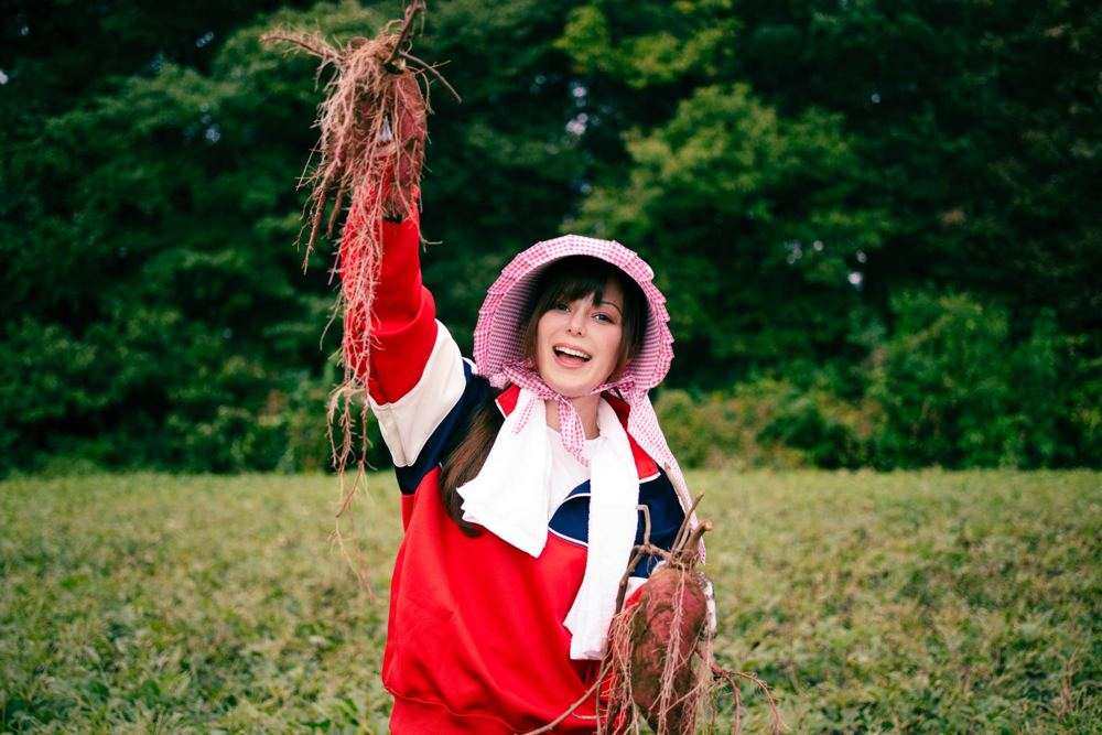 収穫したさつまいもを持つ農家の女性